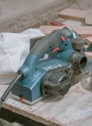 professional electric planer on the wooden surface